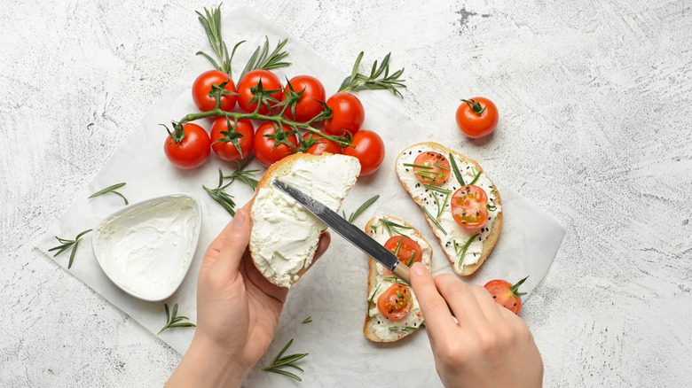 Person spreading cashew cream cheese on bread