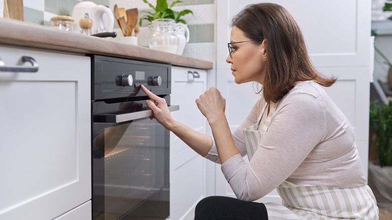 woman setting oven temperature