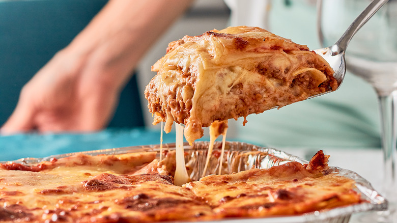 person serving lasagna