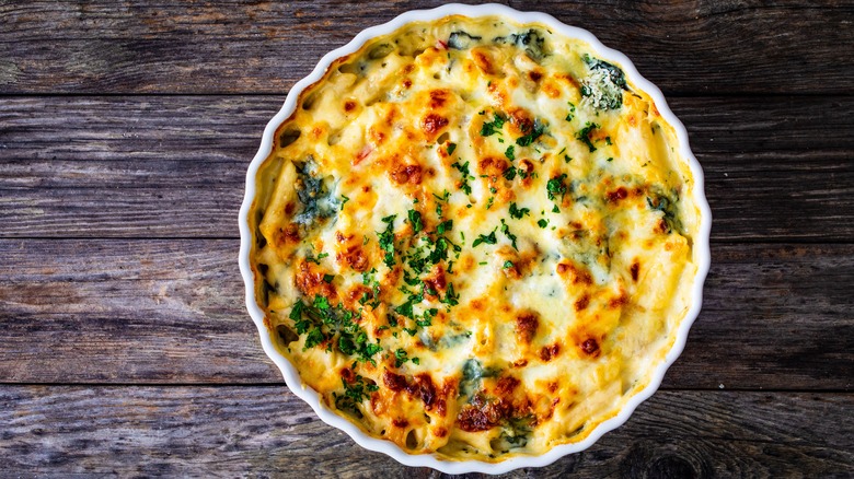 Cheesy casserole against wood background