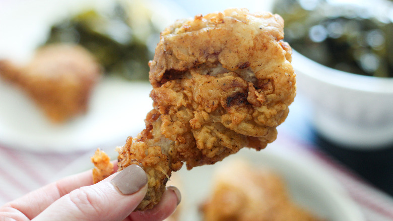 hand holding fried chicken drumstick