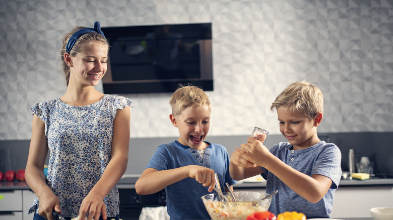 three children making slaw salad