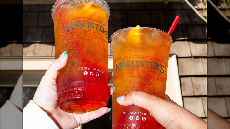 two people holding McAlister's beverages