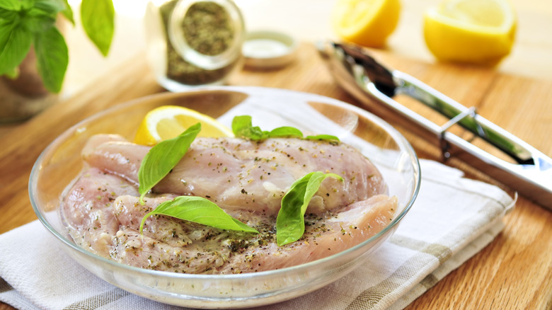 Chicken marinating in clear bowl