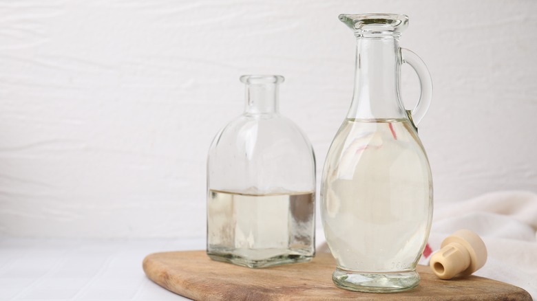 two bottles of vinegar on a serving board