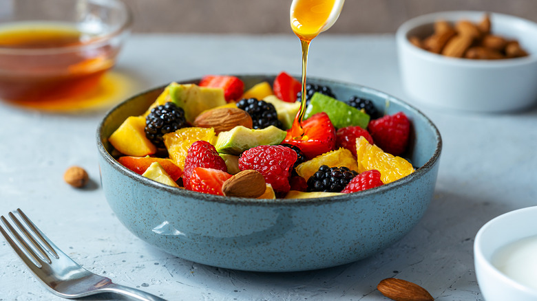 Drizzling fruit salad with honey