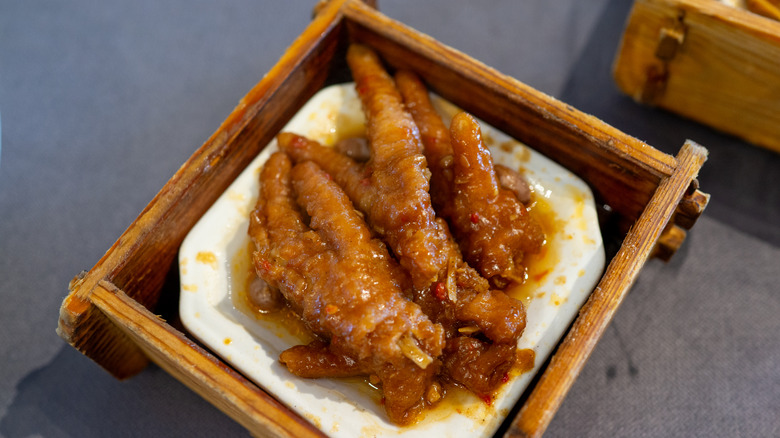 Glazed chicken feet on a small white dish