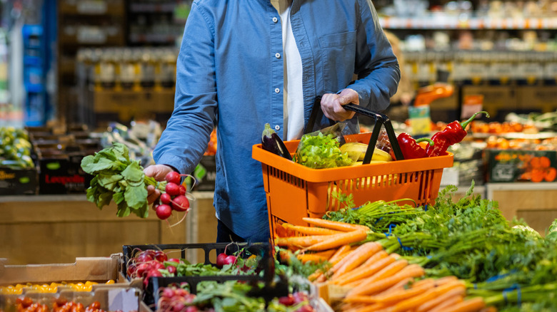 Person shopping in produce section at grocery store