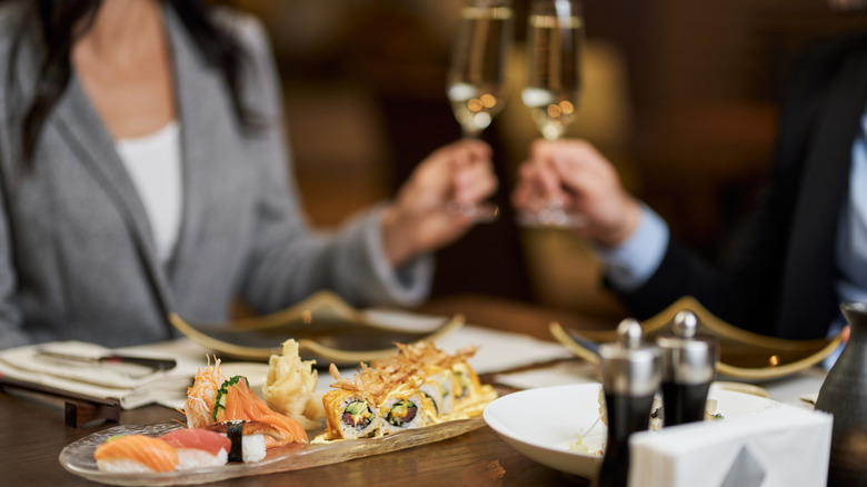 Two people having champagne with sushi