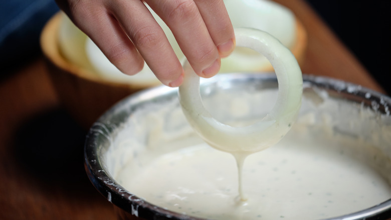 person battering onion ring