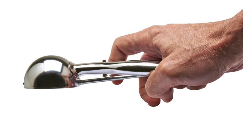 Hand holding ice cream scooper