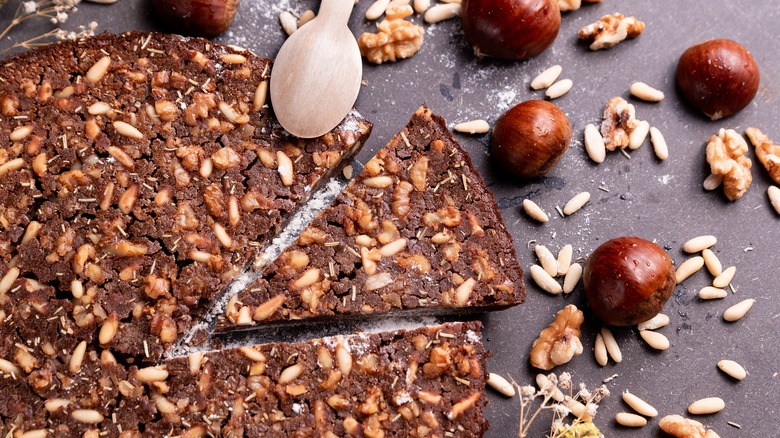 Castagnaccio with chestnuts on dark surface