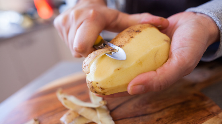 Person peeling potato.