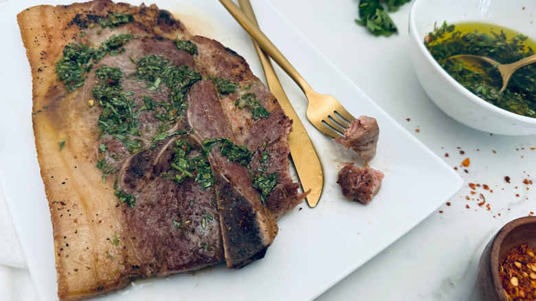 pork steak with chimichurri on white plate