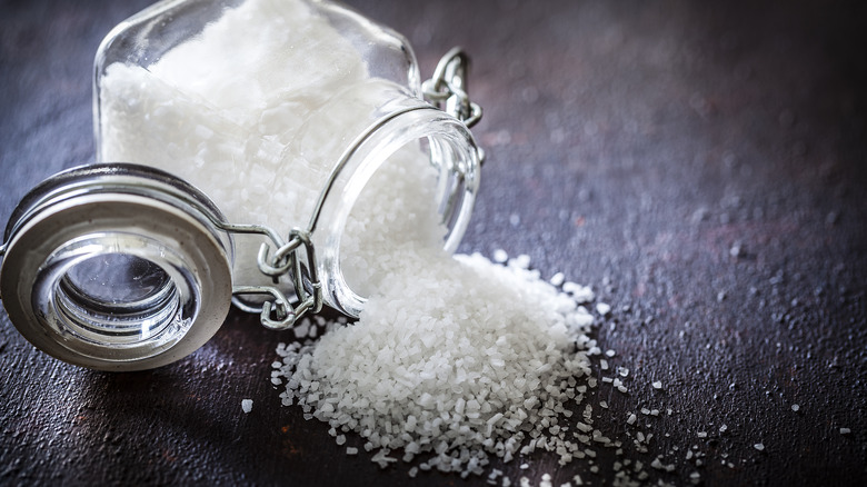 sea salt spilled on table from jar