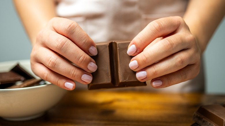 hands breaking a chocolate bar