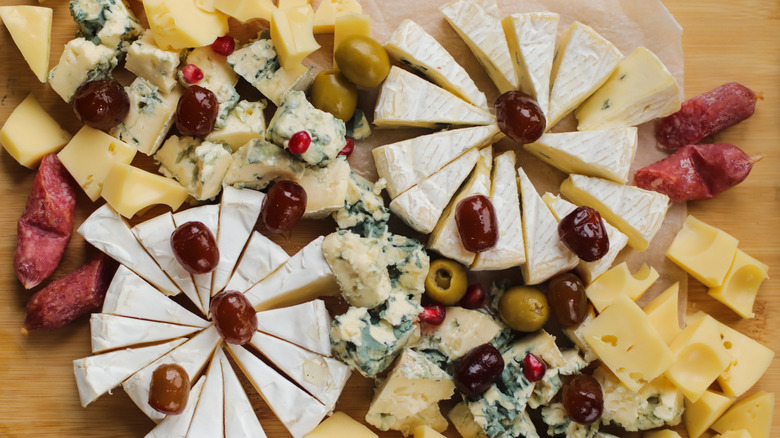 Overhead view of charcuterie board with assorted cheese and olives