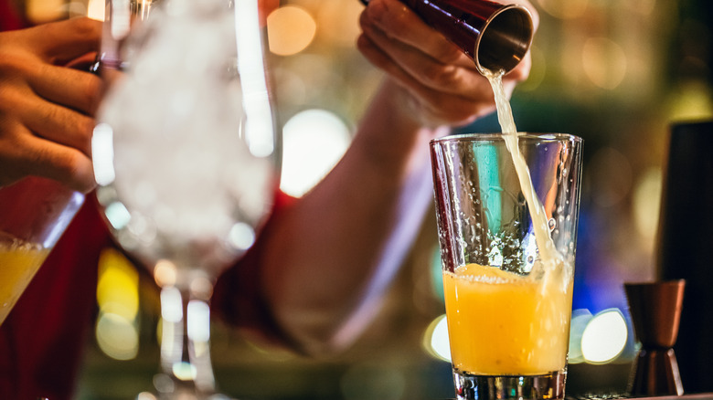 making a drink with citrus juice at bar