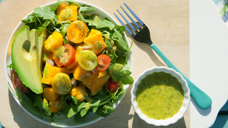 A salad with green dressing on the side