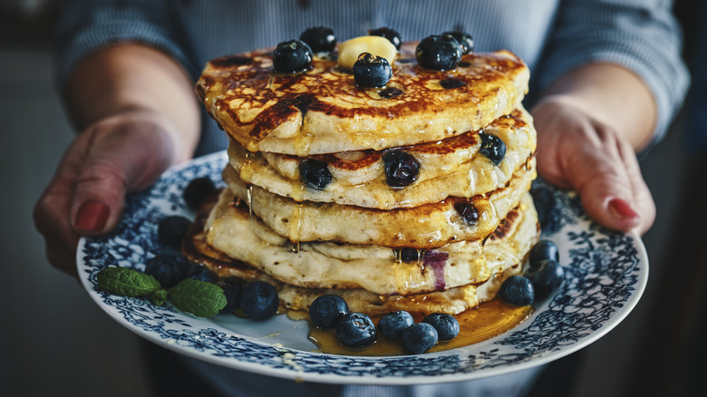 Person serving a plate of pancakes