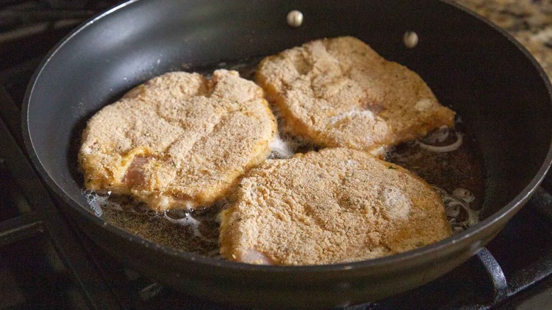 breaded pork chops in a pan