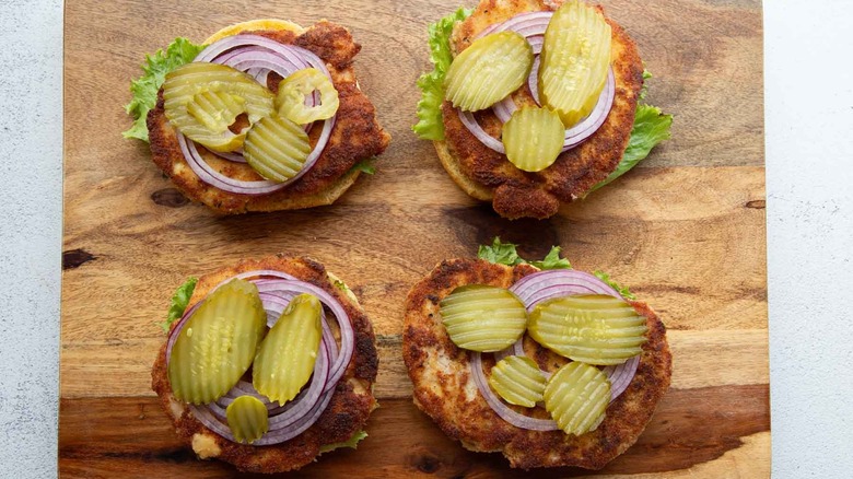 pork chop sandwiches with pickles and red onion