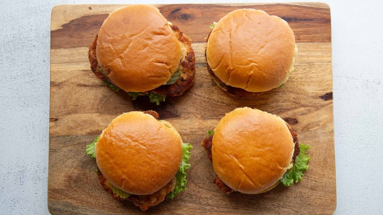 fried pork chop sandwiches on a wooden board