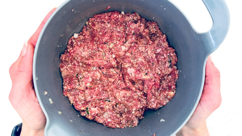 hands holding ground meat mixture