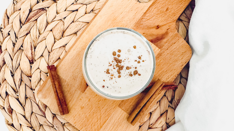 horchata glass on cutting board with cinnamon sticks