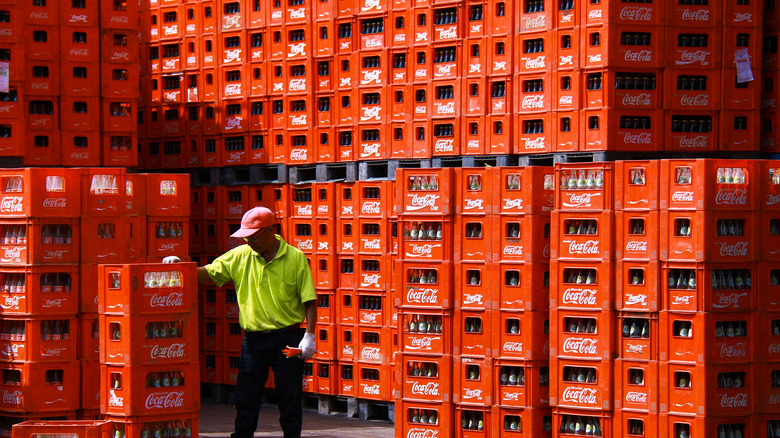 worker stacking crates of Coca-Cola