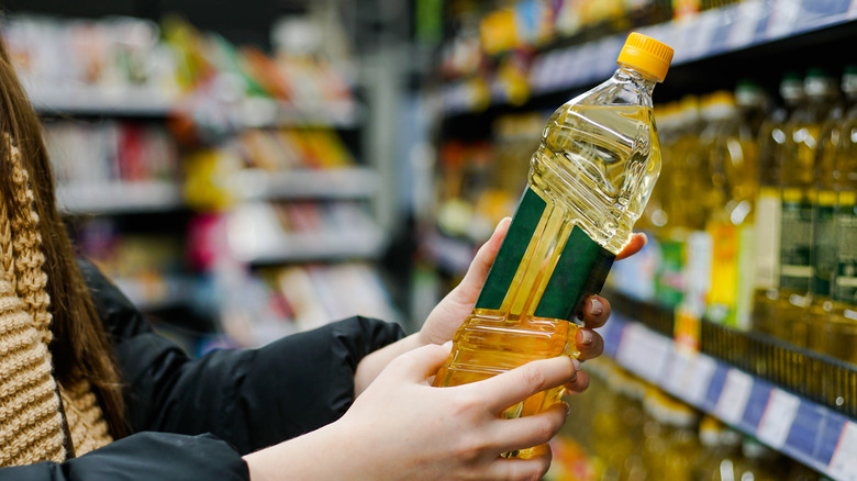 Person holding oil at market