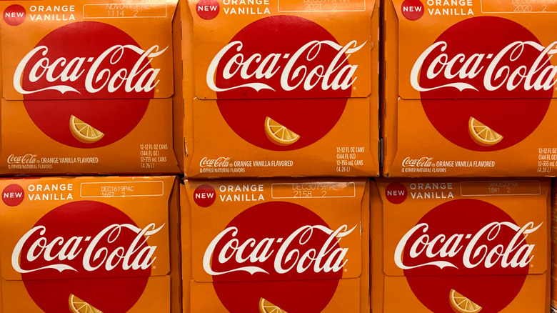 Six stacked boxes of 12-pack cans of orange vanilla Coke