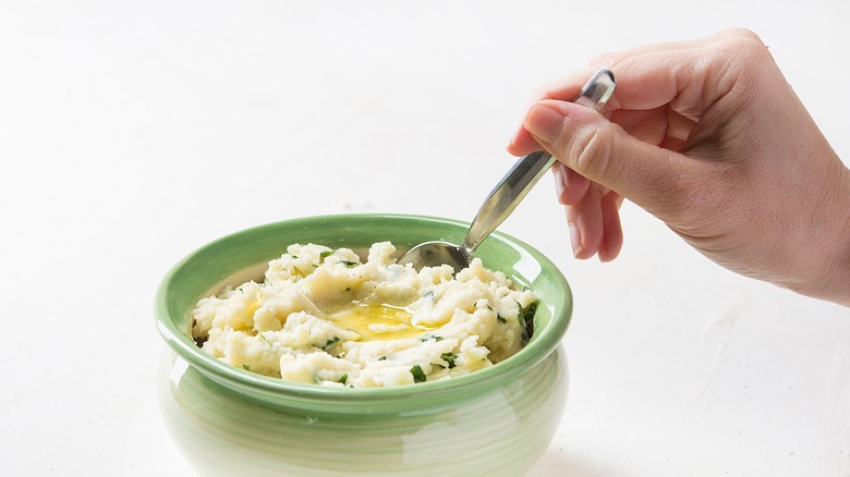 spooning colcannon from a bowl