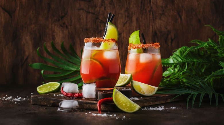 Michelada in cup sliced limes around it