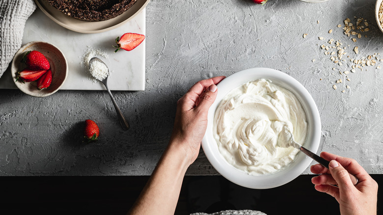 hands mixing yogurt