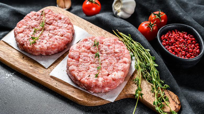 turkey burger patties with herbs on a cutting board