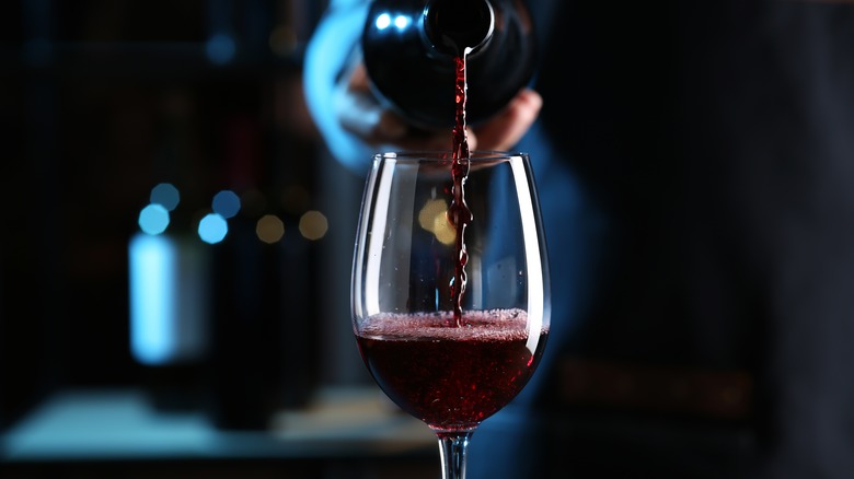 bartender pouring a glass of red wine