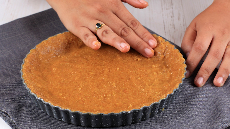 pressing pie crust into pan 