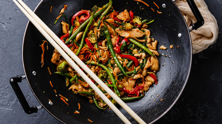 Chopsticks over wok with stir fry