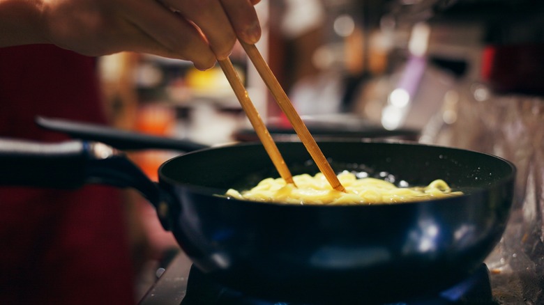 Cooking with chopsticks in frying pan