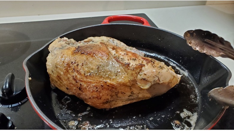 Costco's premade Thanksgiving meal turkey in a pan on a stove