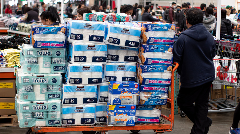 Man buying multiple cases of toilet paper at grocery store