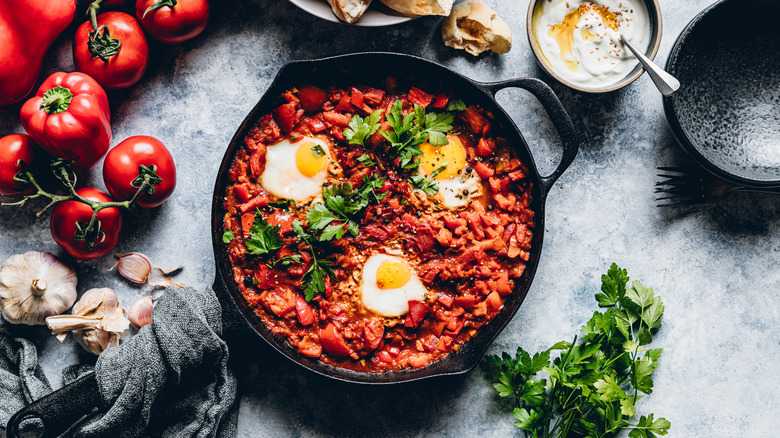 Skillet of poached eggs in tomatoes