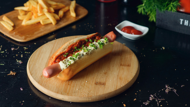 hot dog with red sauce, white sauce, and chives