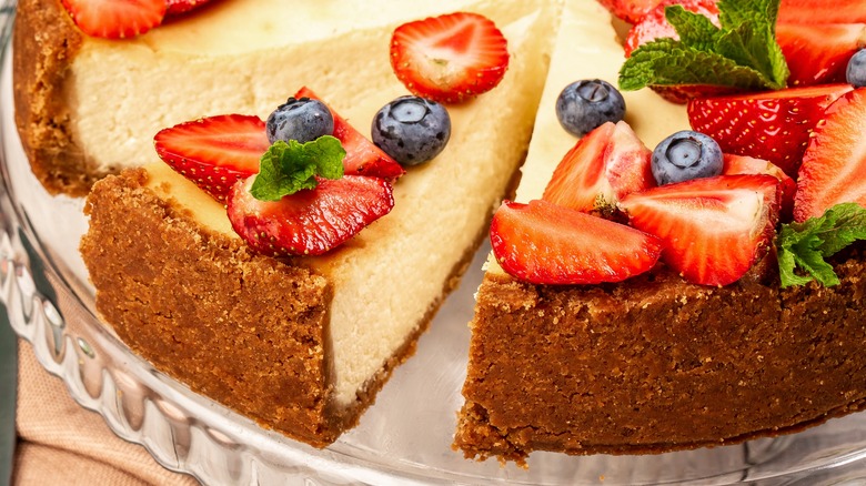 fruit covered cheesecake on glass platter 