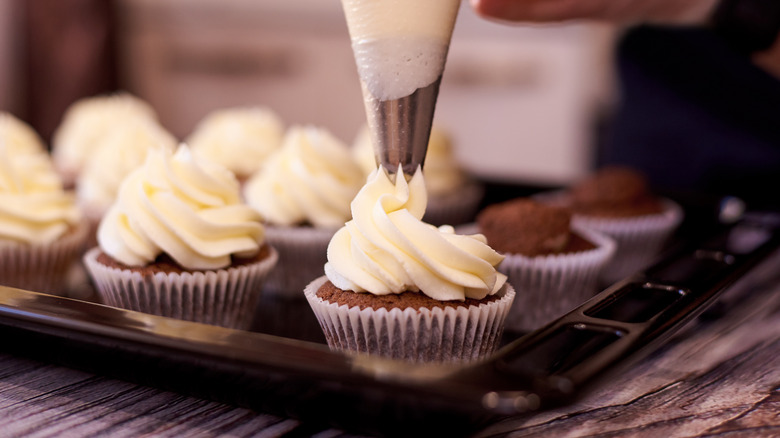 Pipiing frosting on cupcakes