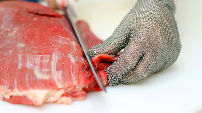 Butcher trimming meat