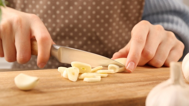 garlic cut into pieces on wooden board