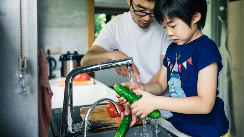 parent and child washing cucumbers