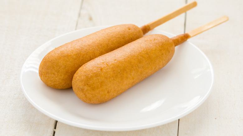 Corn dogs on white plate